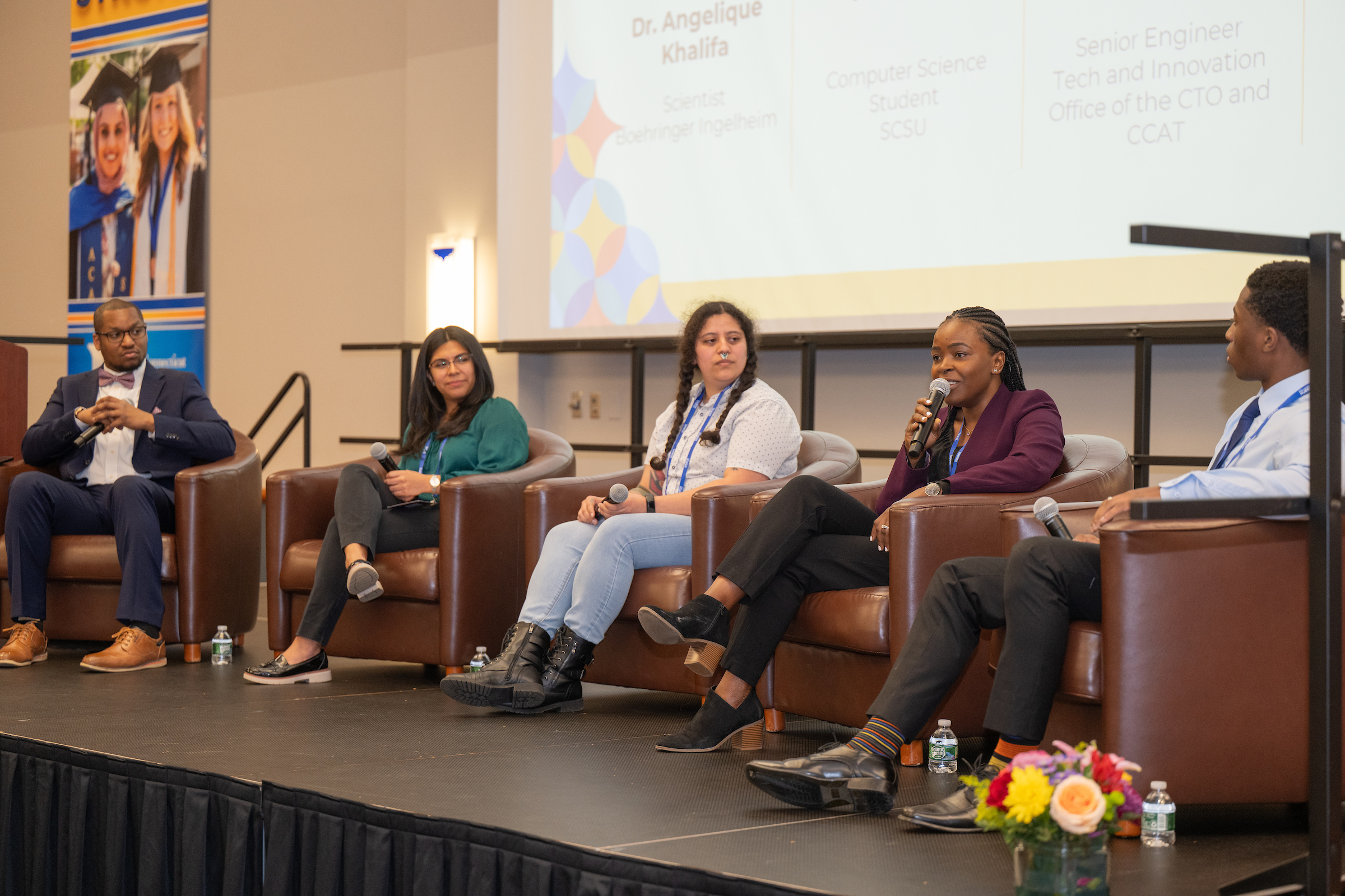 four panelists sitting on a stage
