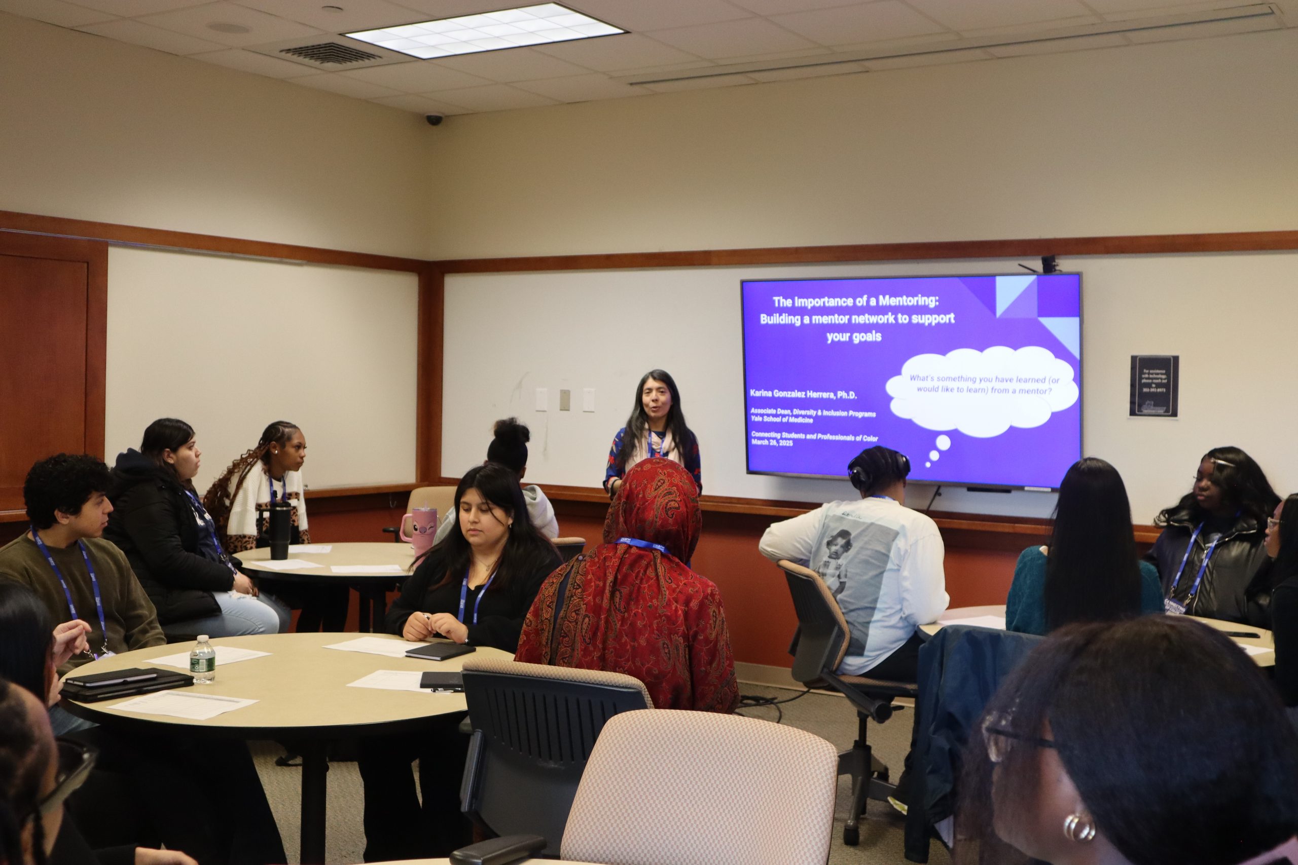 students sitting and listening to a speaker in a small session