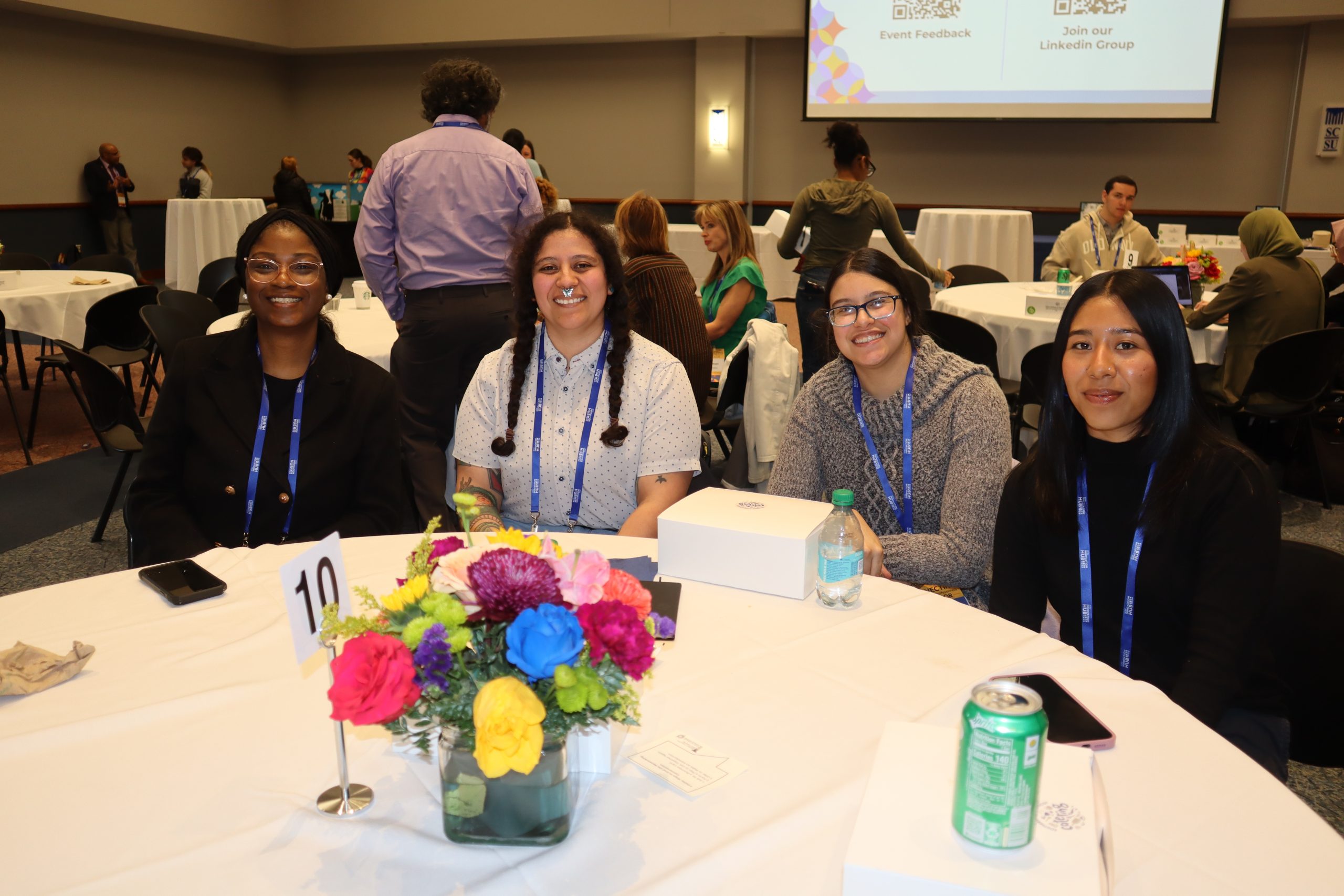 attendees sitting at a table smiling