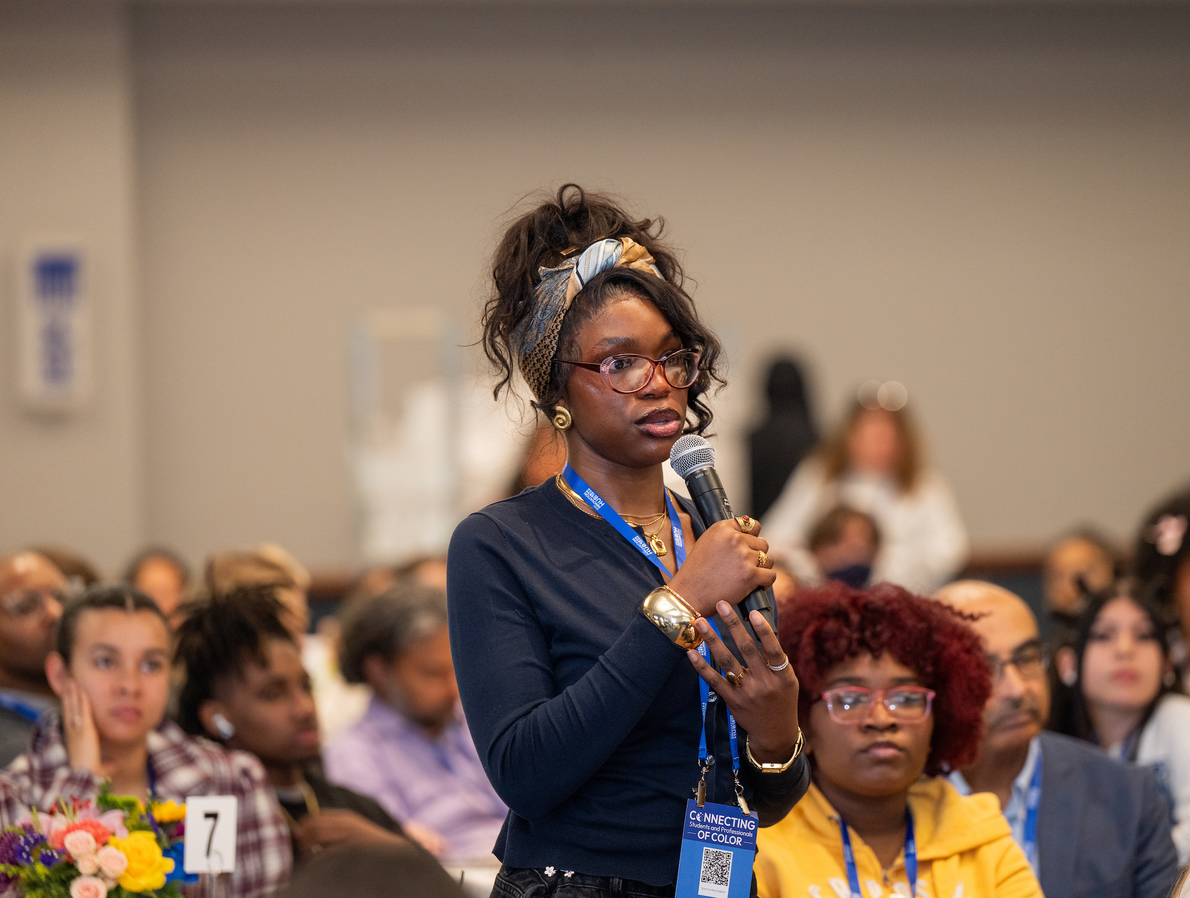 student attendee asking panelists a question using a microphone